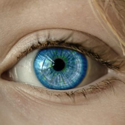 Primer plano de un ojo humano mostrando detalles del iris y pestañas, representando salud visual y precisión óptica.